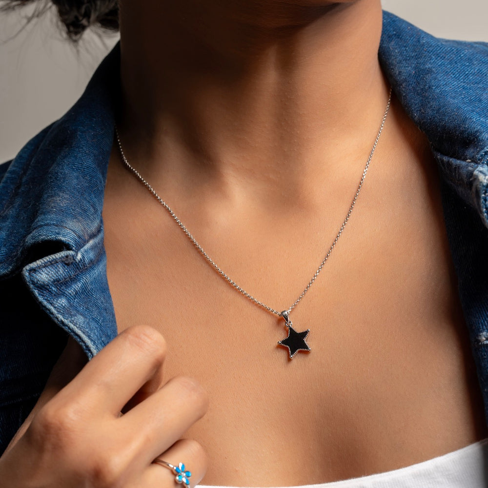 Stylist layering Klarity’s black star pendant sliver necklace