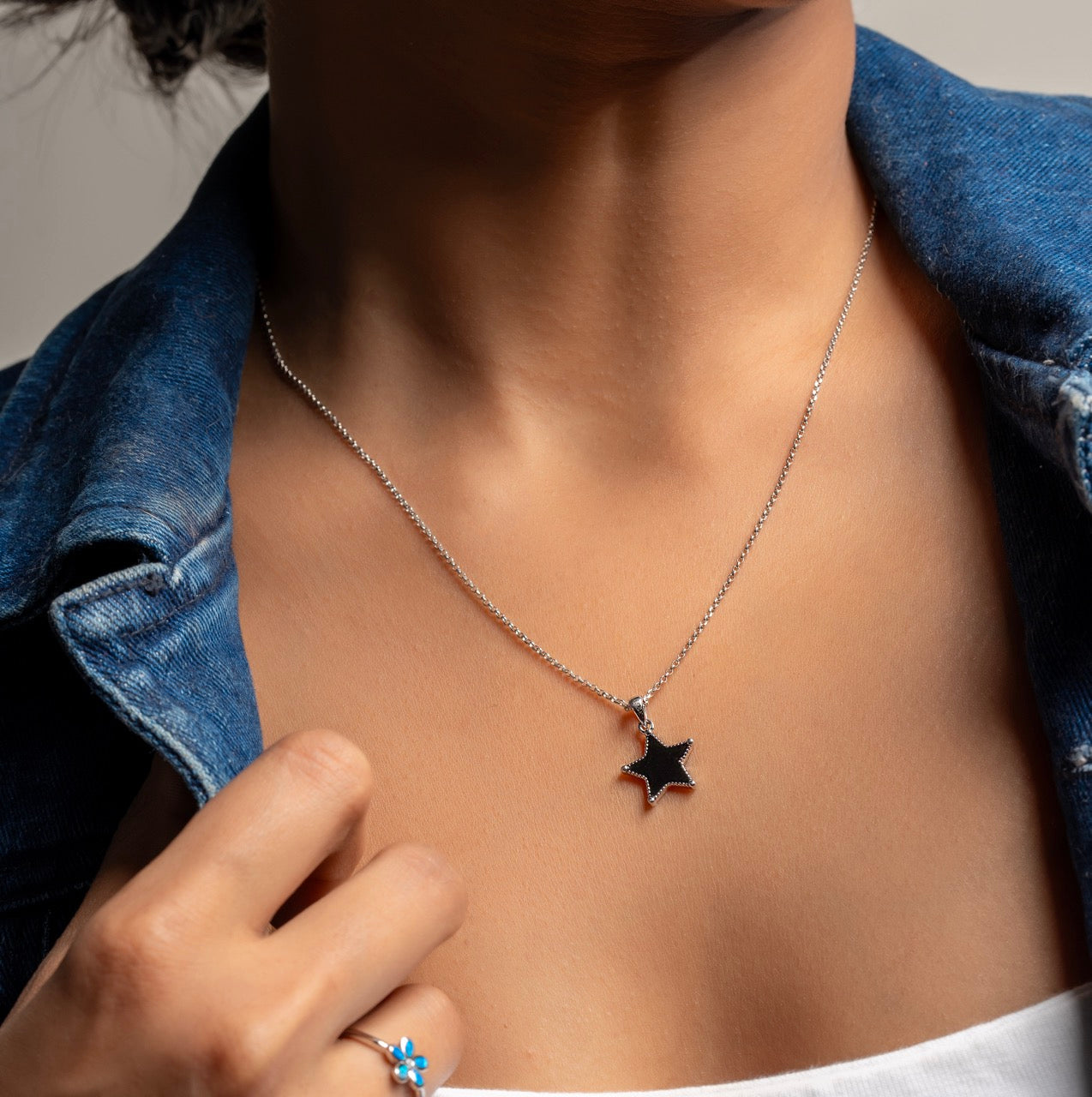 Stylist layering Klarity’s black star pendant sliver necklace