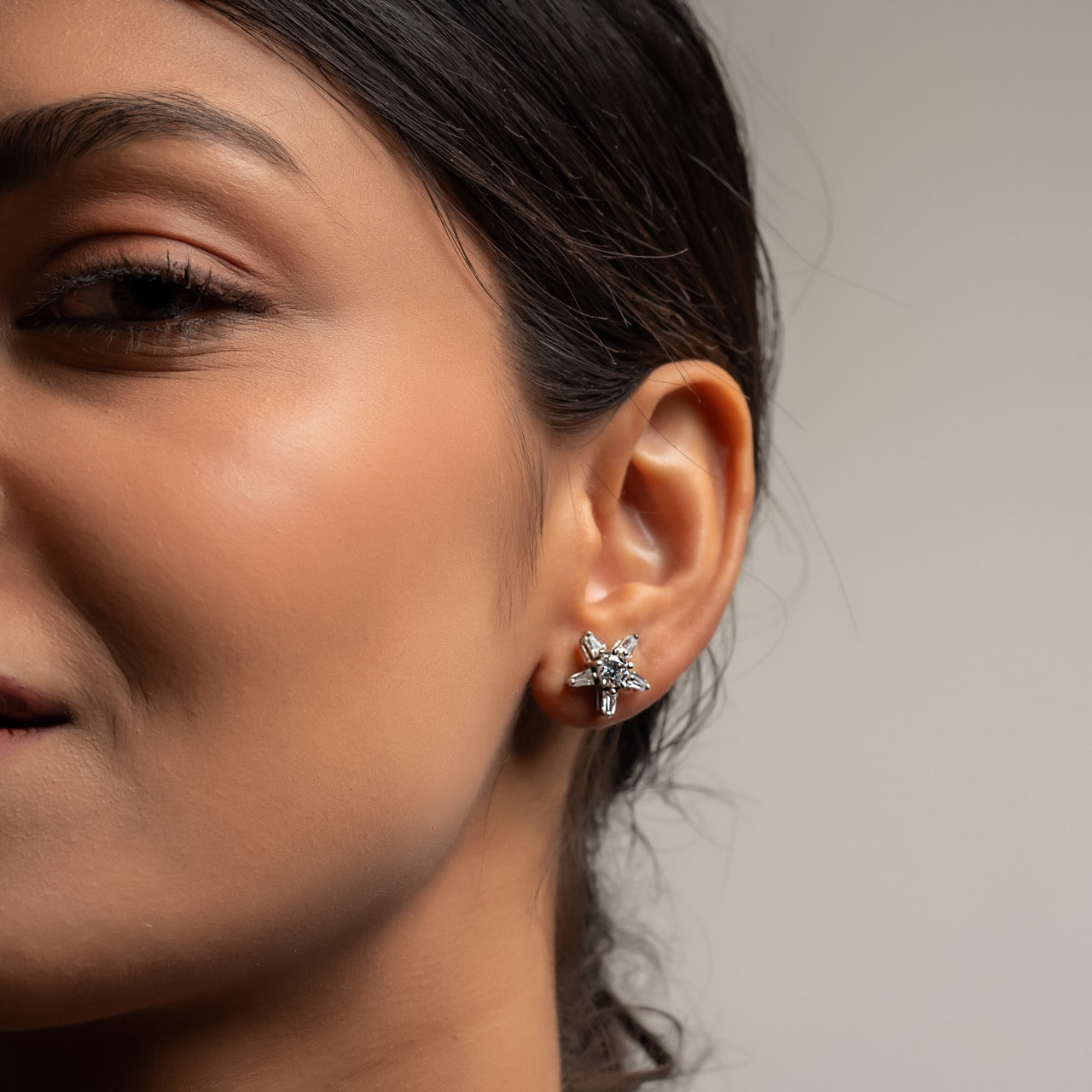 Celestial-inspired silver earrings featuring radiant starburst design