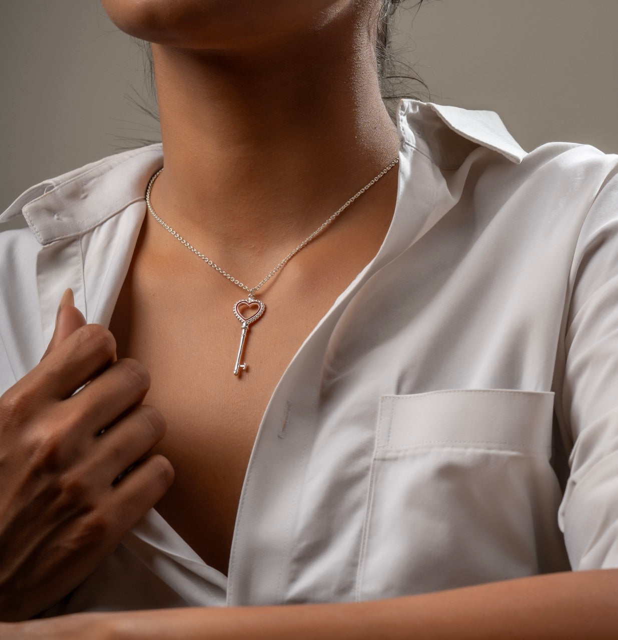Woman wearing heart key pendant necklace with denim for everyday style