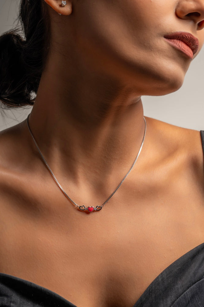 Three-heart pendant by Klarity featuring a vibrant red centerpiece