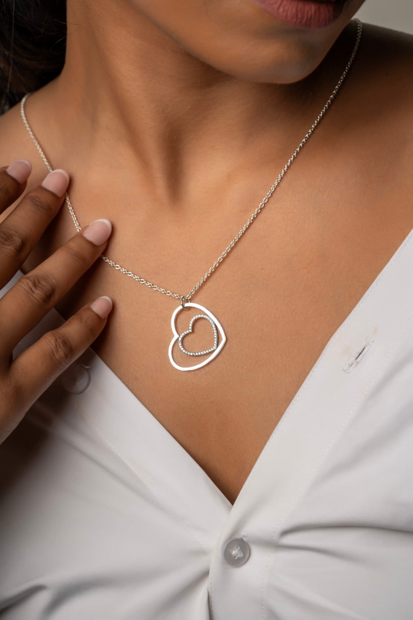 Romantic silver necklace by Klarity featuring one studded and one polished heart
