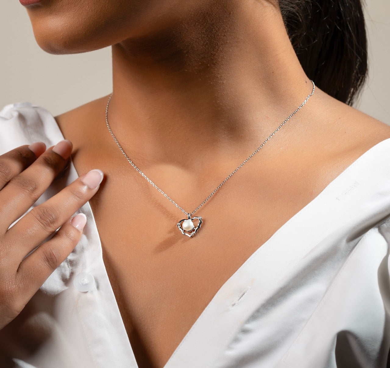 Model wearing Klarity’s  silver pearl heart pendant in white dress - timeless jewellery.
